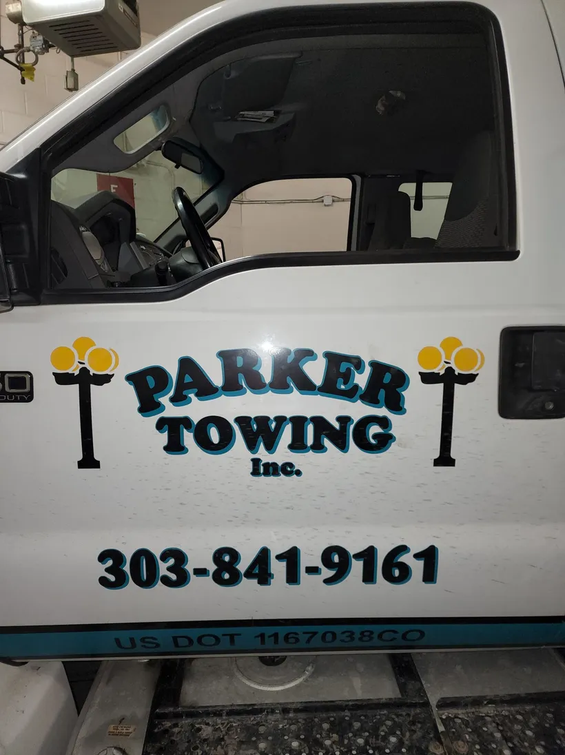 Close-up of a Parker Towing truck door showing the logo and phone number