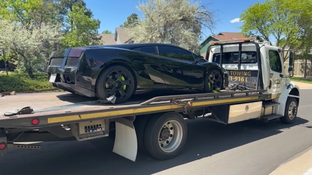 A Parker Towing flatbed loading a customer's car in a Parker, CO neighborhood